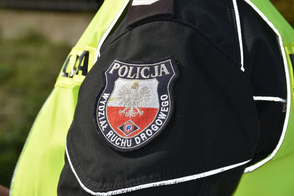 Fragment munduru polskiego policjanta z naszywką Wydziału Ruchu Drogowego na ramieniu.