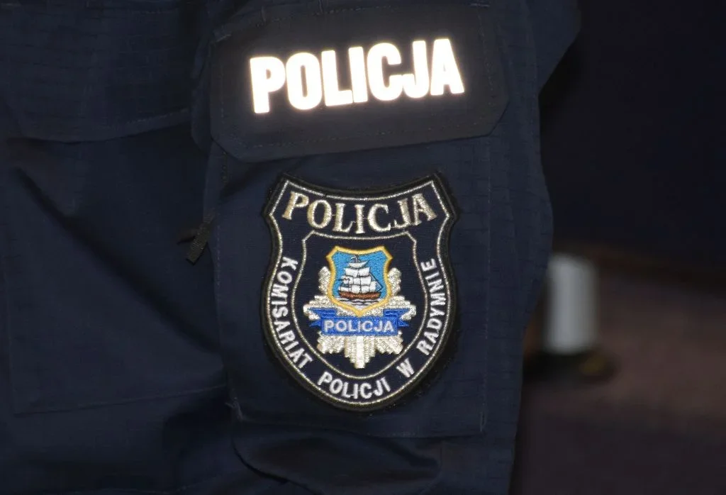 Fragment policyjnego munduru z naszywką komisariatu w Radymnie.