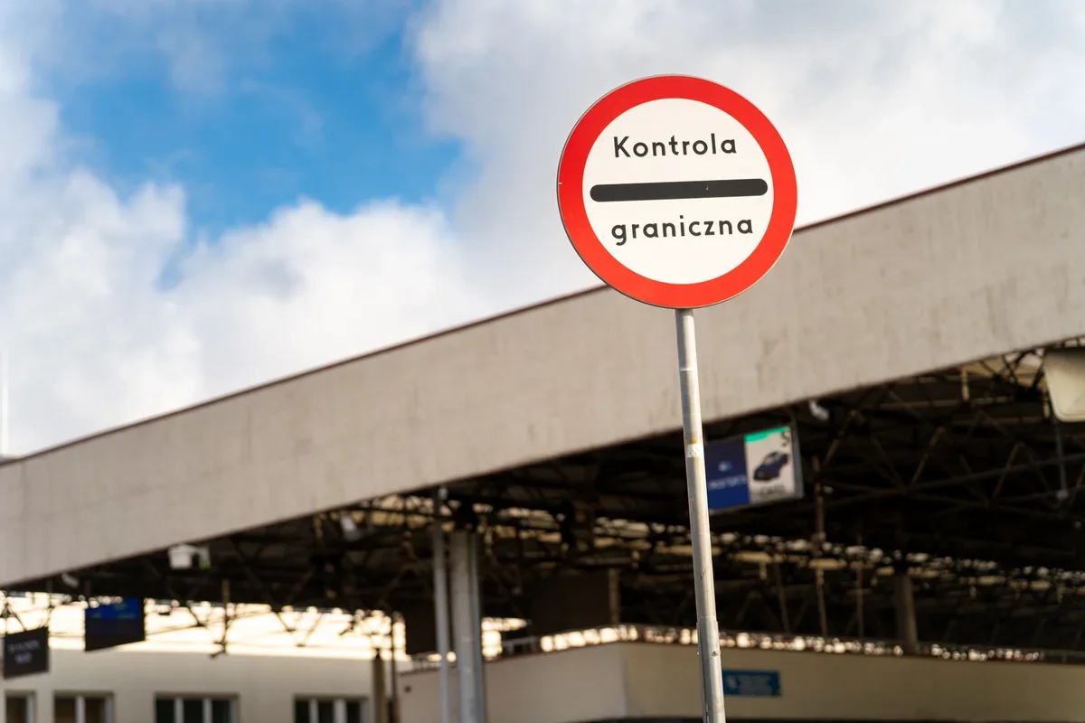Znak drogowy „Kontrola graniczna” przed budynkiem przejścia granicznego.